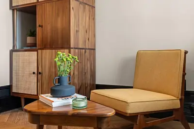 a room with a chair and a table with a vase at Freeman 203 by Rove Travel -1BR Condo with Shared Amenities in New York