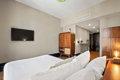 a bedroom with a white bed and a tv at Freeman 203 by Rove Travel -1BR Condo with Shared Amenities in New York