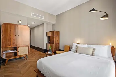 a bedroom with a white bed and a wooden cabinet at Freeman 203 by Rove Travel -1BR Condo with Shared Amenities in New York