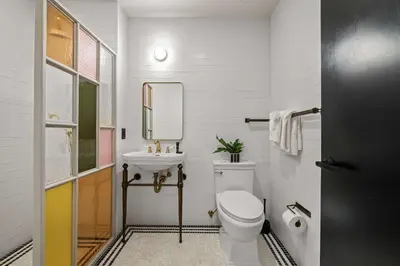 a white bathroom with a toilet and a sink at Freeman 403 by Rove Travel - 1BR Condo with Shared Amenities in New York