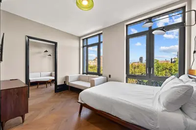 a bedroom with a large white bed and large windows at Freeman 503 by Rove Travel - 1BR Condo with Shared Amenities in New York