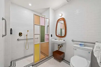 a bathroom with a toilet and a sink and a mirror at Freeman 503 by Rove Travel - 1BR Condo with Shared Amenities in New York