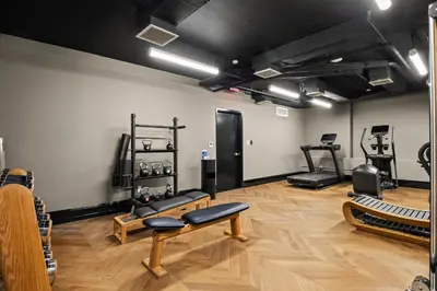 a room with a gym with benches and equipment at Freeman 503 by Rove Travel - 1BR Condo with Shared Amenities in New York