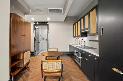 a kitchen with a table and some chairs in it at Freeman 503 by Rove Travel - 1BR Condo with Shared Amenities in New York