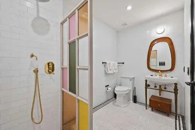 a bathroom with a sink and a toilet and a mirror at Freeman 803 by Rove Travel - 1BR Condo with Shared Amenities in New York