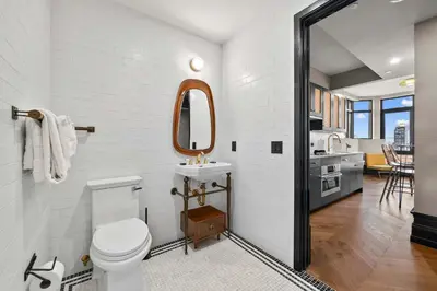 a white bathroom with a sink and a mirror at Freeman 803 by Rove Travel - 1BR Condo with Shared Amenities in New York