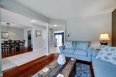 a living room with a blue couch and a table at Poconos Retreat Hot Tub, Pool, Theater EV chrg & more in Blakeslee