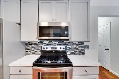 a kitchen with a stove and a microwave at Poconos Retreat Hot Tub, Pool, Theater EV chrg & more in Blakeslee
