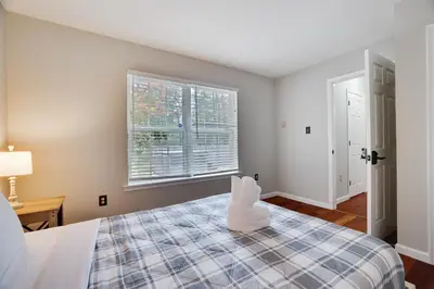 a bedroom with a bed and a window at Poconos Retreat Hot Tub, Pool, Theater EV chrg & more in Blakeslee