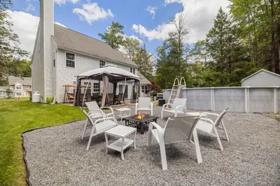 a patio with chairs and a table and a gazebo at Poconos Retreat Hot Tub, Pool, Theater EV chrg & more in Blakeslee