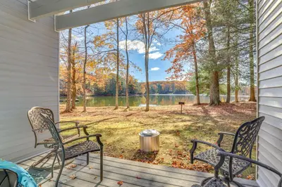 a screened porch with two chairs and a view of a lake at Steps to Lake Tanglwood Tranquil Wooded Retreat in Greentown