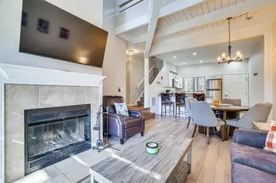 a living room with a fireplace and a dining room at Steps to Lake Tanglwood Tranquil Wooded Retreat in Greentown