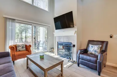a living room with a fireplace and two chairs at Steps to Lake Tanglwood Tranquil Wooded Retreat in Greentown