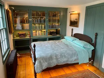 a bedroom with a bed and a book shelf at Historic Canal Home on Nature Preserve in Princeton