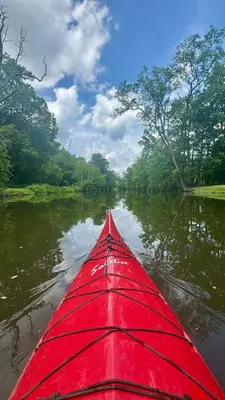 a red kayak is in the water on a river at Historic Canal Home on Nature Preserve in Princeton