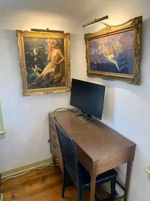 a desk with a computer and two paintings on the wall at Historic Canal Home on Nature Preserve in Princeton
