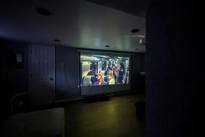 a living room with a large tv in a dark room at Private Luxurious Canal Estate in Princeton
