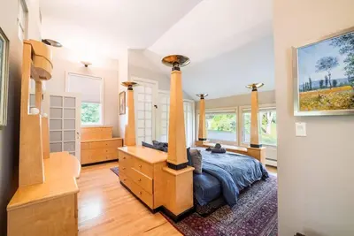 a bedroom with a bed and a dresser and windows at Private Luxurious Canal Estate in Princeton
