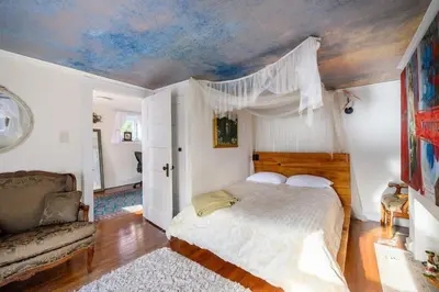 a bedroom with a bed and a couch at Charming & Whimsical Historic River Home in Titusville