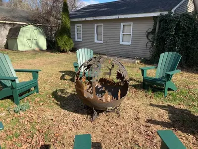 two chairs and a globe in a yard with a house at Charming & Whimsical Historic River Home in Titusville