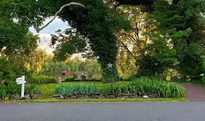 a garden with a bench and a table and plants at Charming & Whimsical Historic River Home in Titusville