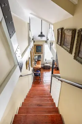 a hallway with stairs and paintings on the walls at Unique Luxury Central Historic Landmark Home in Lambertville