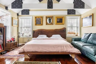 a bedroom with a large bed and a couch at Unique Luxury Central Historic Landmark Home in Lambertville