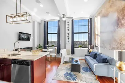 a kitchen and living room with a blue couch at Sleek NoLibs 1BR - Pool & Gym in Philadelphia