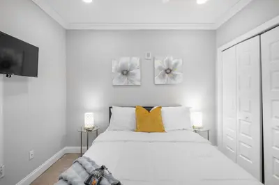 a white bedroom with a white bed with yellow pillows at Sleek NoLibs 1BR - Pool & Gym in Philadelphia