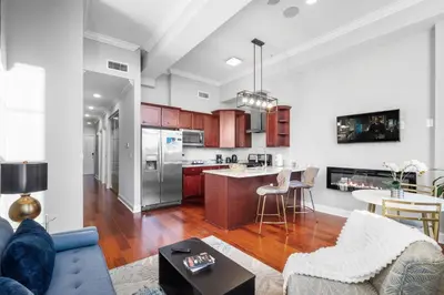 an open kitchen and living room with a blue couch at Sleek NoLibs 1BR - Pool & Gym in Philadelphia