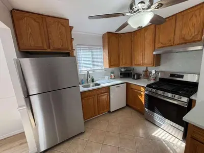 a kitchen with wooden cabinets and a stainless steel refrigerator at Entire Cozy Apartment Fully Renovated Modern Style in North Brunswick