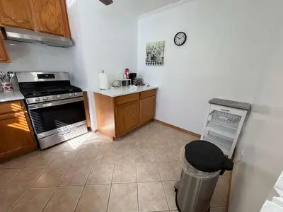 a kitchen with a stove and a trash can at Entire Cozy Apartment Fully Renovated Modern Style in North Brunswick