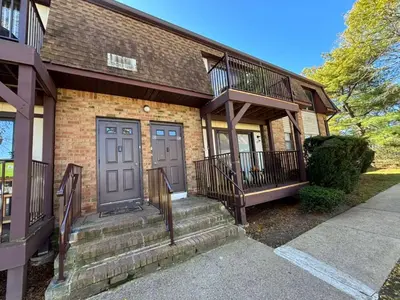 a brick house with a staircase leading to the front door at Entire Cozy Apartment Fully Renovated Modern Style in North Brunswick