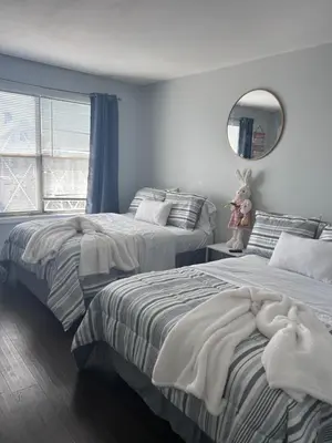 a bedroom with two beds and a mirror and a window at Kickback and relax in Elizabeth