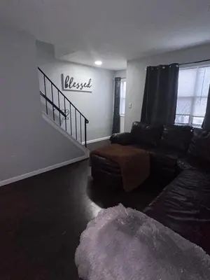 a living room with a couch and a stair case at Kickback and relax in Elizabeth