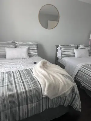 a bedroom with two beds and a mirror on the wall at Kickback and relax in Elizabeth