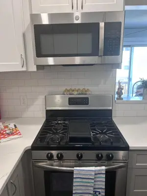 a kitchen with a stove top oven with a microwave at Kickback and relax in Elizabeth