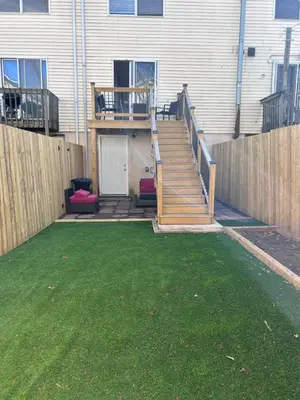 a backyard with a wooden staircase and a fence at Kickback and relax in Elizabeth