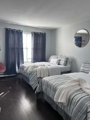 a bedroom with two beds and a mirror at Kickback and relax in Elizabeth
