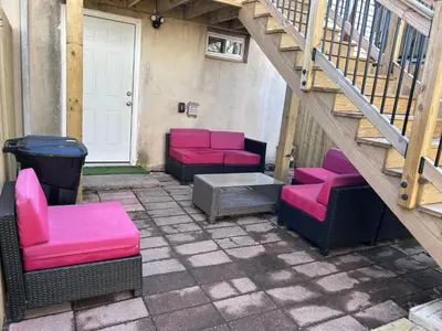 a patio with pink and black chairs and stairs at Kickback and relax in Elizabeth