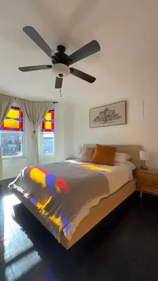 a bedroom with a bed with a ceiling fan at Bright & Spacious Home close to NYC and World Cup in Bayonne