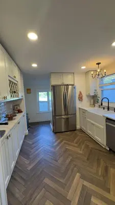 a kitchen with a stainless steel refrigerator and wooden floors at Bright & Spacious Home close to NYC and World Cup in Bayonne