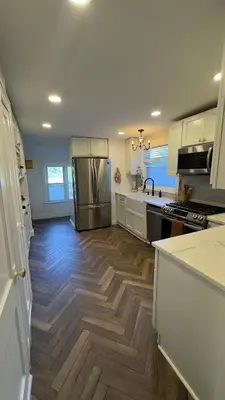 a kitchen with a refrigerator and a wooden floor at Bright & Spacious Home close to NYC and World Cup in Bayonne