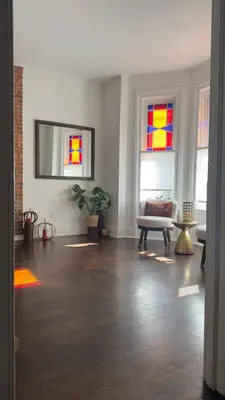 a living room with two stained glass windows at Bright & Spacious Home close to NYC and World Cup in Bayonne