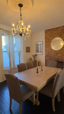 a dining room table with chairs and a chandelier at Bright & Spacious Home close to NYC and World Cup in Bayonne