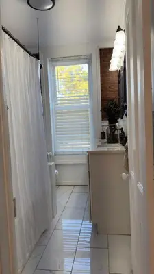 a bathroom with a shower and a sink and a window at Bright & Spacious Home close to NYC and World Cup in Bayonne