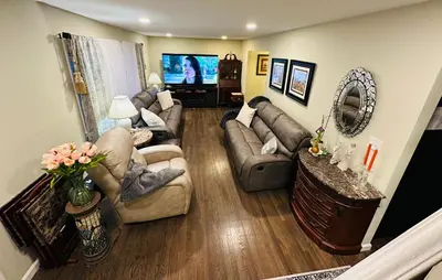 a living room with couches and a flat screen tv at The Princeton Three Cozy 3BR Retreat, BBQ Patio - Shared Home in Trenton