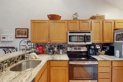 a kitchen with wooden cabinets and a sink and microwave at Vista at Camelback Mountain in Tannersville