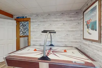 a room with a table with a surfboard on the wall at Vista at Camelback Mountain in Tannersville