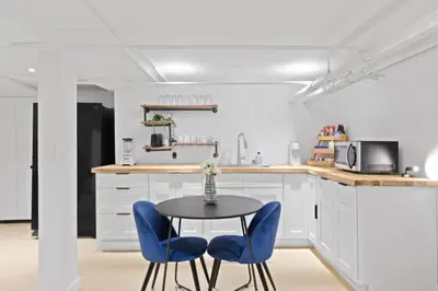 a kitchen with a table and two blue chairs at 20 Mins to Times Sq. EWR | Cozy Apartment | Sleeps 4 in Jersey City